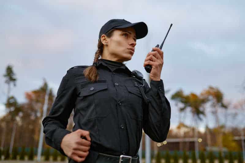 Patrol service police woman talking into walkie-talkie